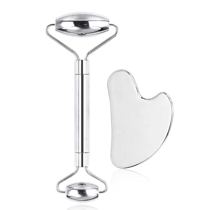 Stainless steel facial massage board set with heart-shaped eye roller and scraping plate on simple packaging