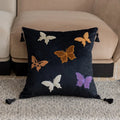 Square decorative cushion with embroidered butterfly pattern in beige, black, or purple colours.