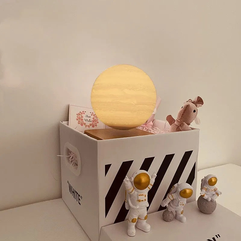 Maglev Earth and Moon night light floating above base with three astronaut figurines nearby.
