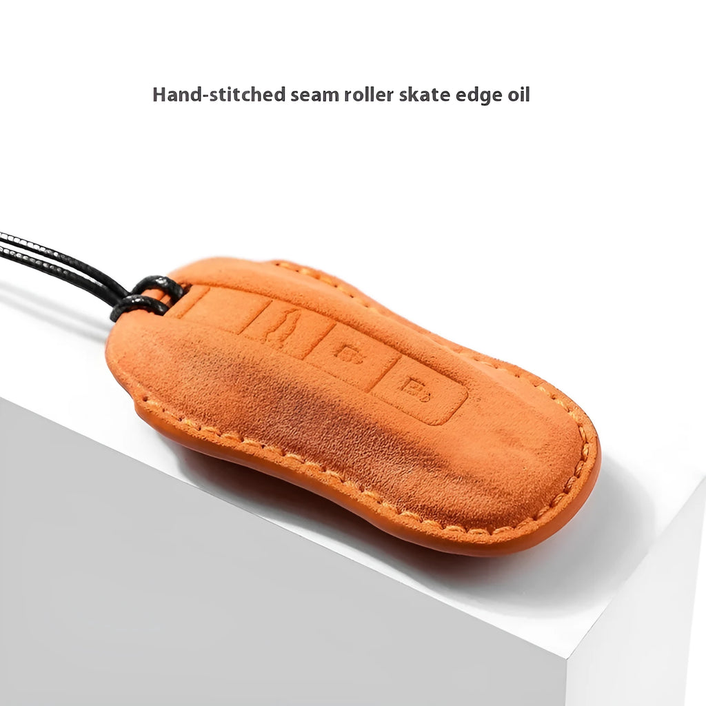 Suede car key cover in cement gray with style A design on a tabletop