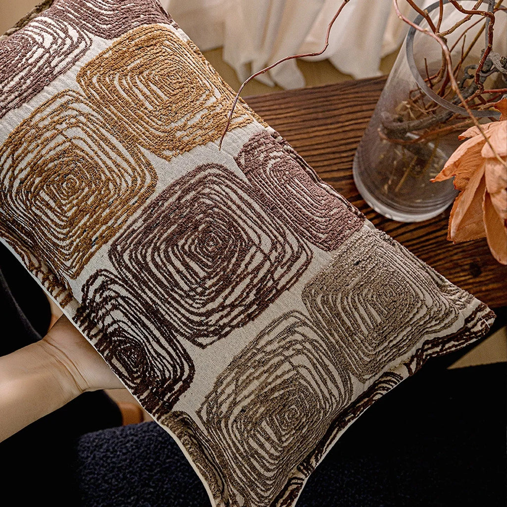 Cream and coffee-coloured abstract coil pattern on a square decorative pillow cover.