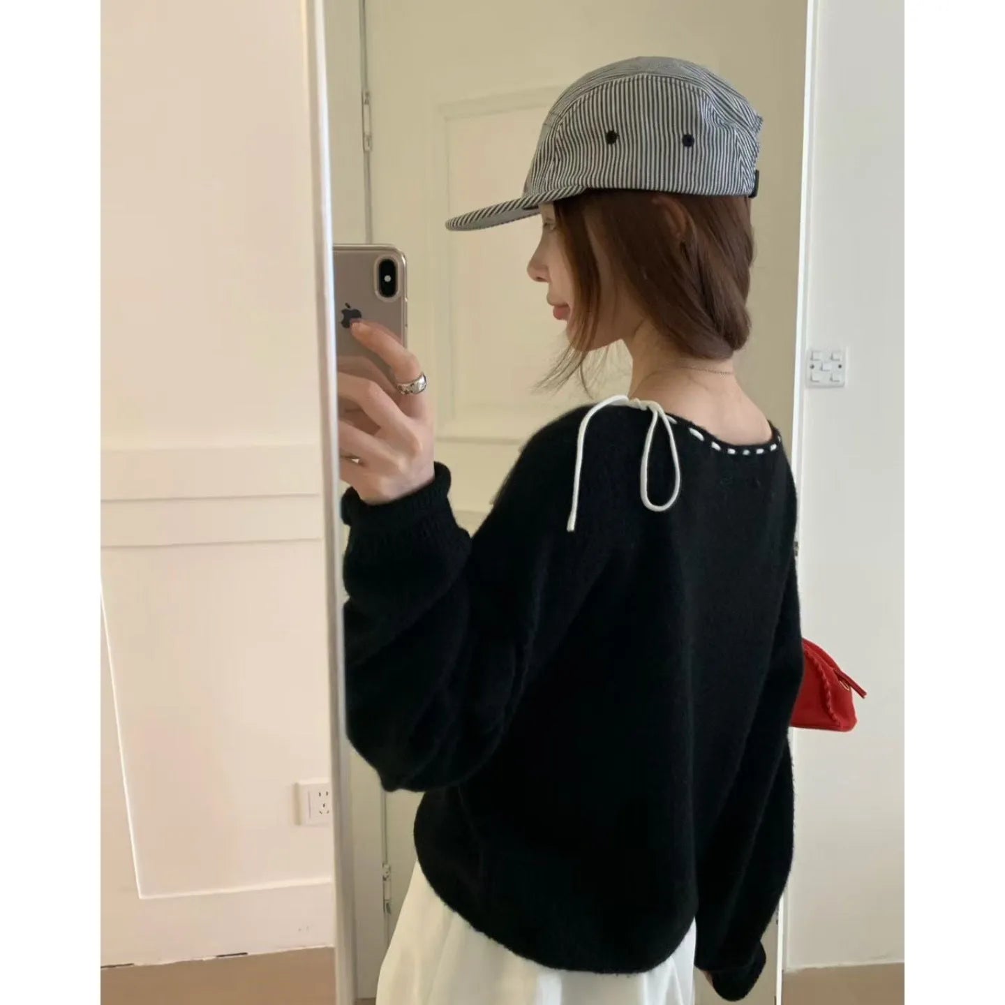 Women's loose-fitting grey knitwear pullover top with long sleeves on a hanger