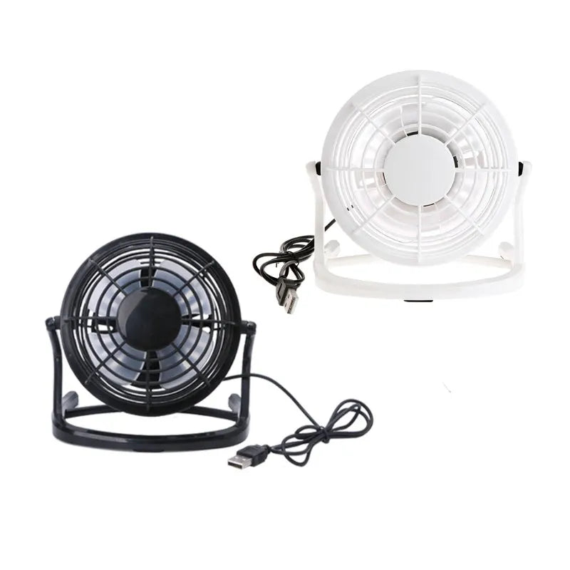 Mini adjustable USB desk fan in black on a desk next to a laptop