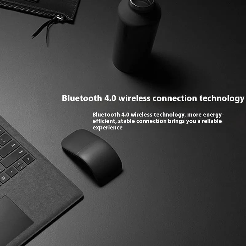 Black folding Bluetooth wireless touch mouse shown in open and closed positions next to a laptop.