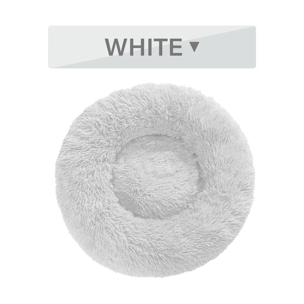 Fluffy donut-shaped dog bed in long plush fabric, shown in a light grey colour without a zipper.