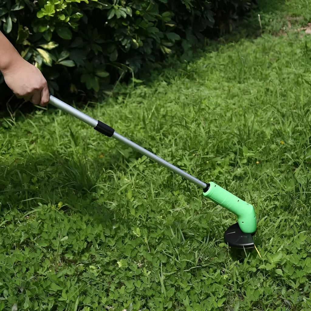 Cordless handheld zip trimmer with extension pole and debris shield on grass