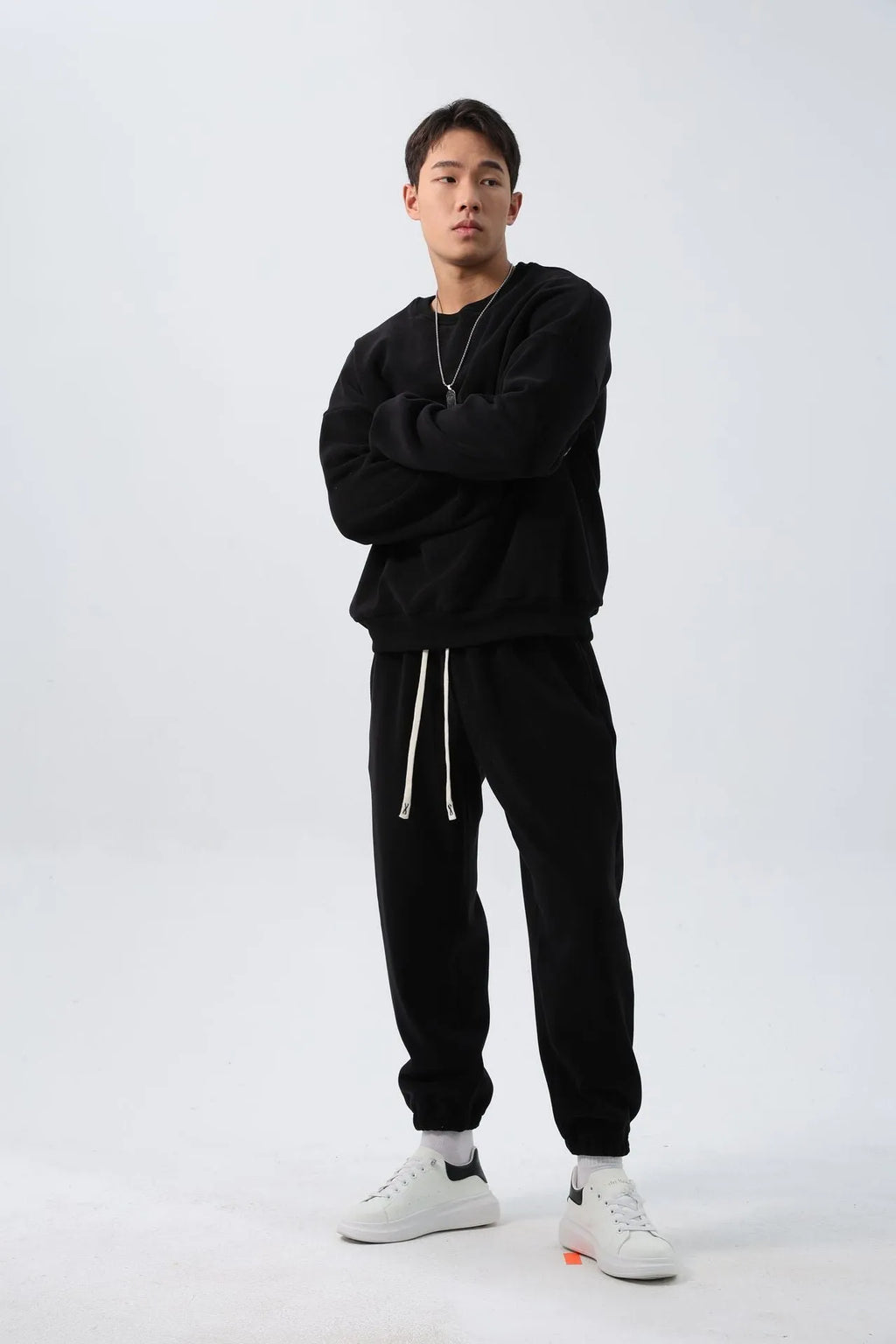 Man wearing a black loose-fit polar fleece sports suit with crew neck top and padded trousers for winter.