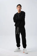 Man wearing a black loose-fit polar fleece sports suit with crew neck top and padded trousers for winter.
