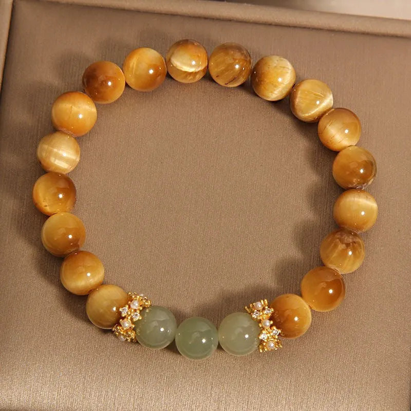 Natural yellow tiger's eye Hetian jade bracelet with diamond polish and auspicious pattern on white background