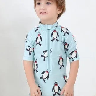 Boys' long-sleeve penguin print swimsuit set with matching swimming cap on mannequin