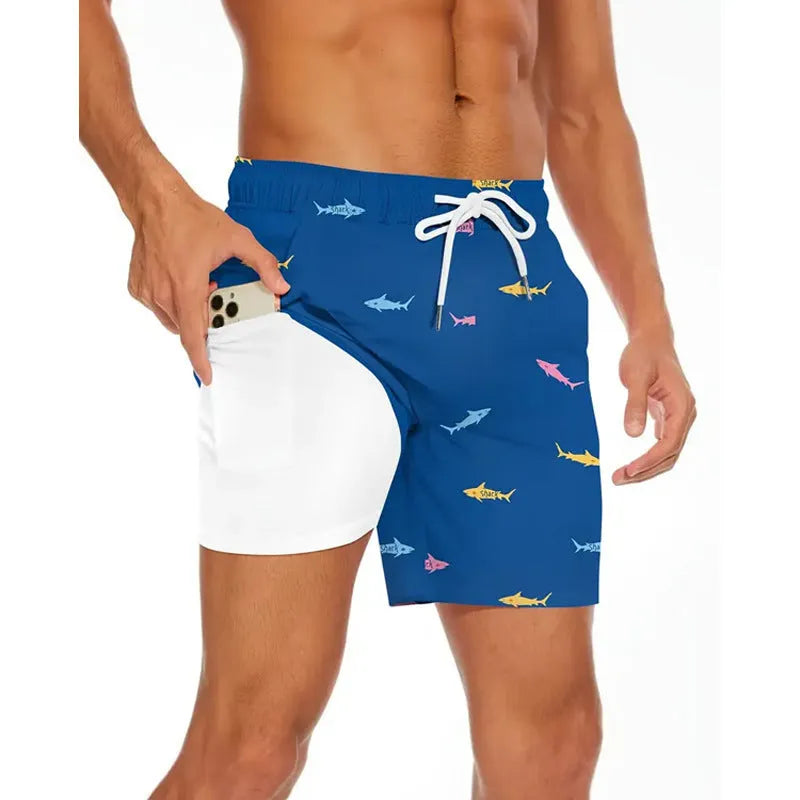 Man wearing loose blue polyester beach shorts on sand, showing relaxed fit and casual style.