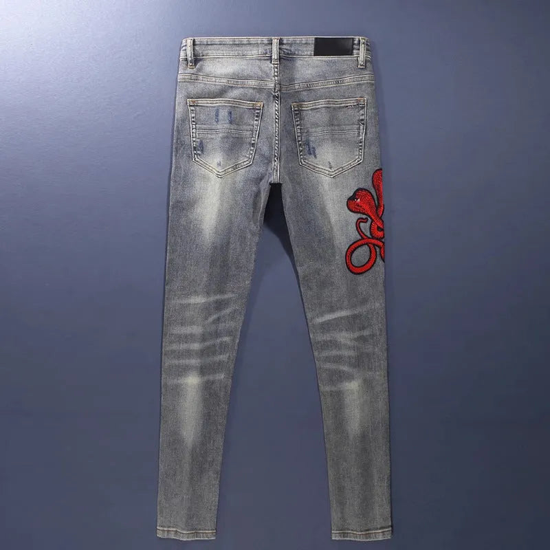 Washed-out old colour slim fit jeans with distressed patches and embroidery detail