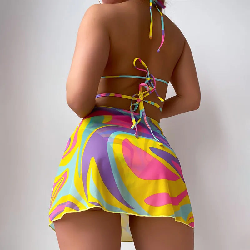 Women's yellow halter lace-up striped swimsuit set with top, skirt, and shorts on a model