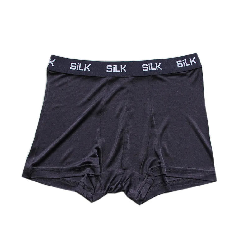 Men's loose-fit silk shorts in navy blue on a mid-waist, showing casual style.