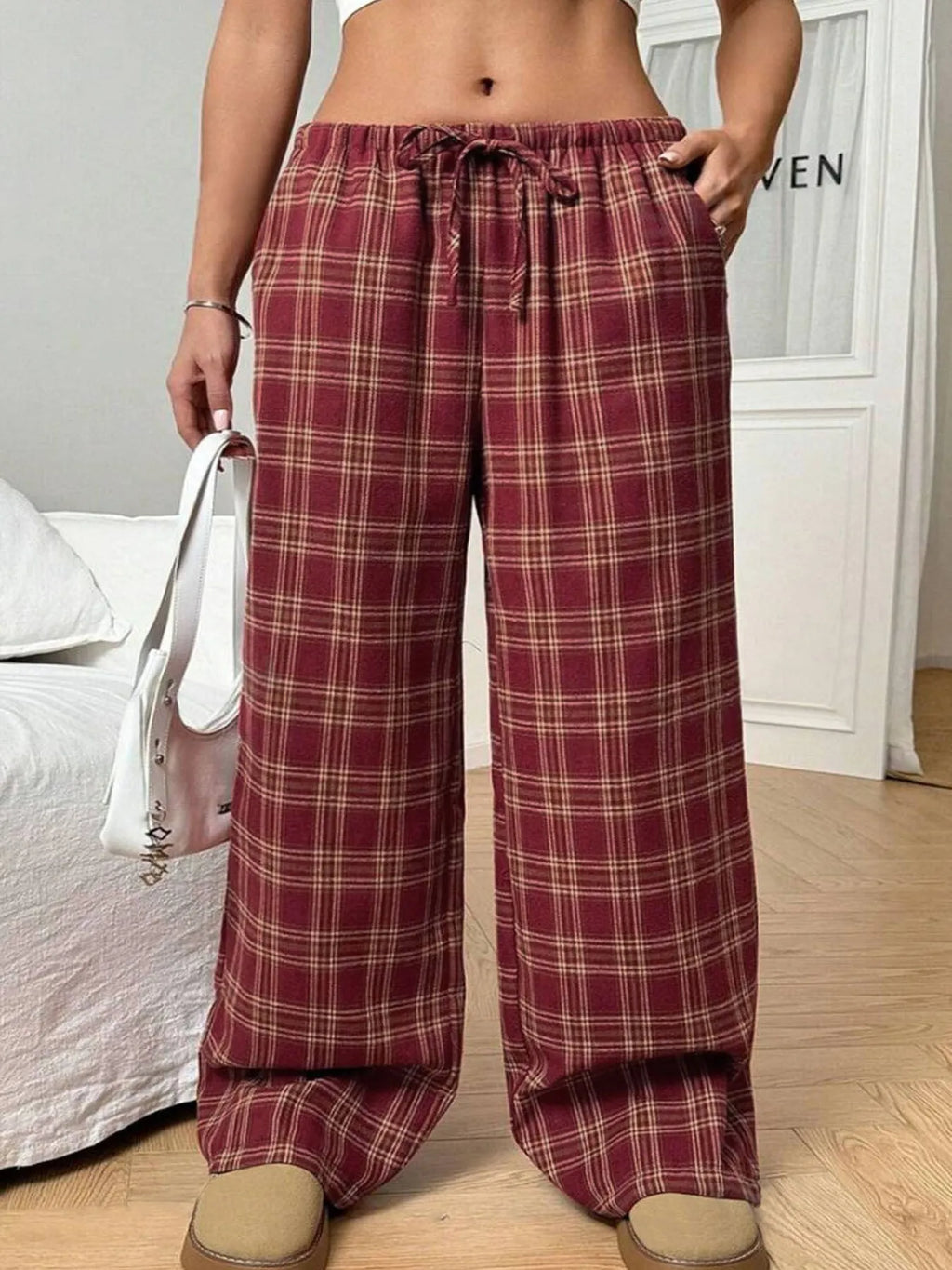 Women's red plaid casual trousers with drawstring waist and side pockets laid flat