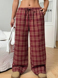 Women's red plaid casual trousers with drawstring waist and side pockets laid flat
