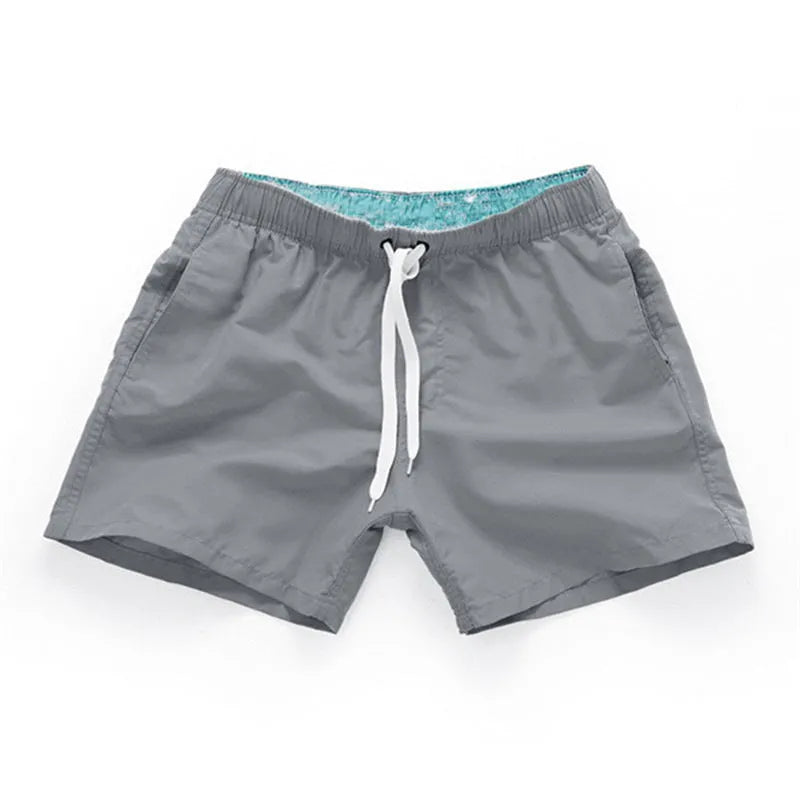 Man wearing soft polyester beach shorts in a straight-leg style, available in multiple colours and plus sizes.