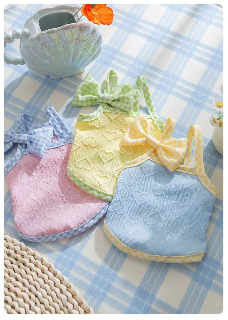 Small dog wearing elastic vest with bow suspenders and heart texture