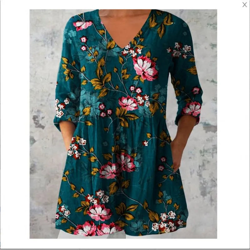 A woman wearing a vibrant printed loose-fitting dress with a wide waist and 3/4 length sleeves.