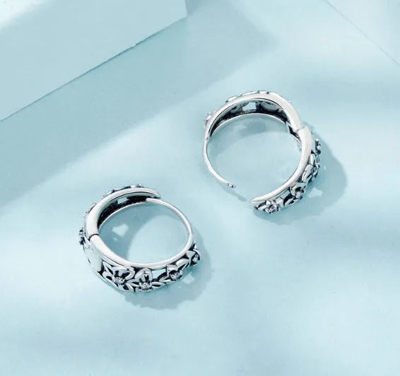 Pair of sterling silver hollow butterfly earrings with zircon accents, showing retro design.