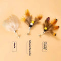 Three steel wire cat toy replacement heads with small flying insect designs on a white background