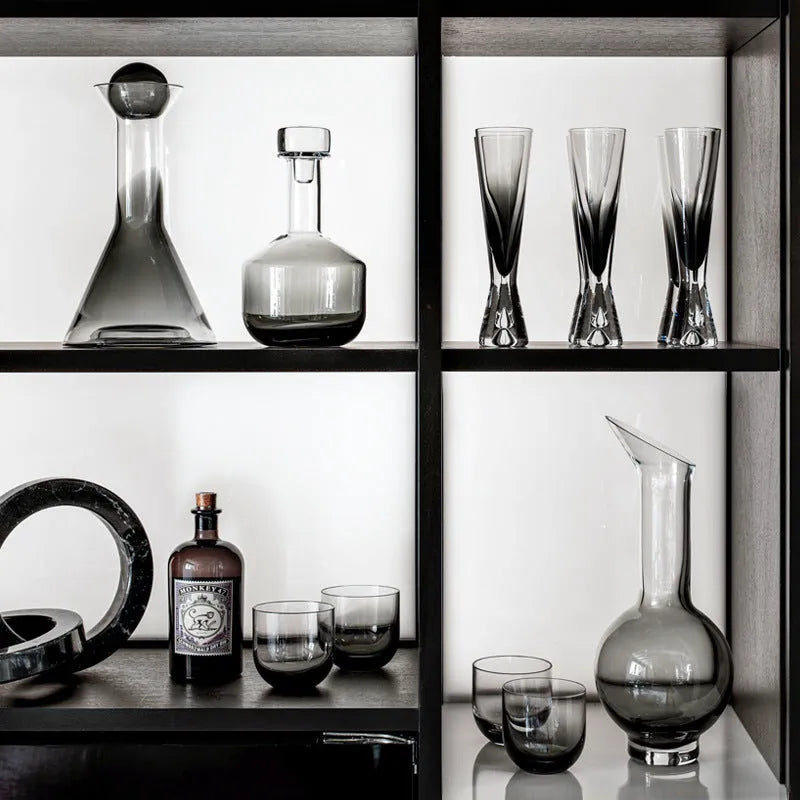 Modern wine accessories set including glassware, ice bucket, and stainless steel ornaments on a table