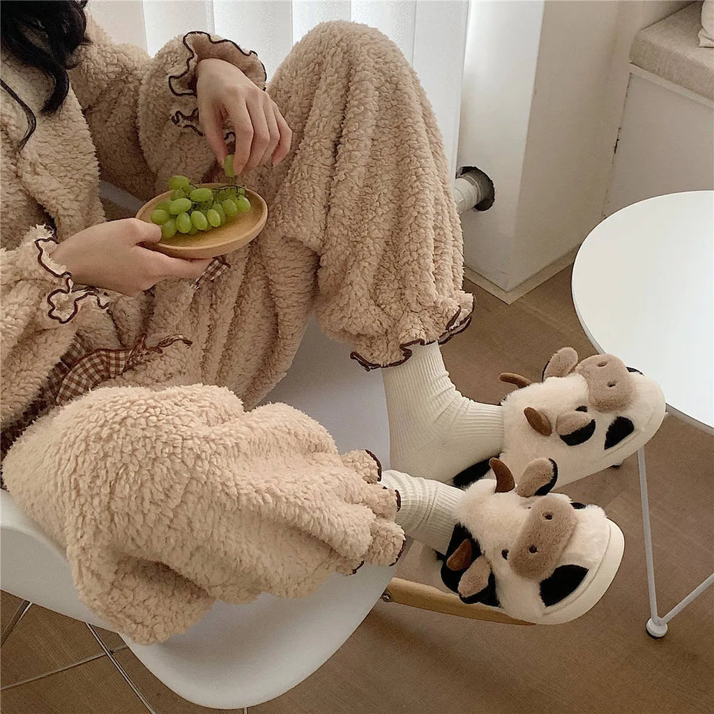 White cartoon cow slippers for women with fluffy faux fur and a textured non-slip sole.