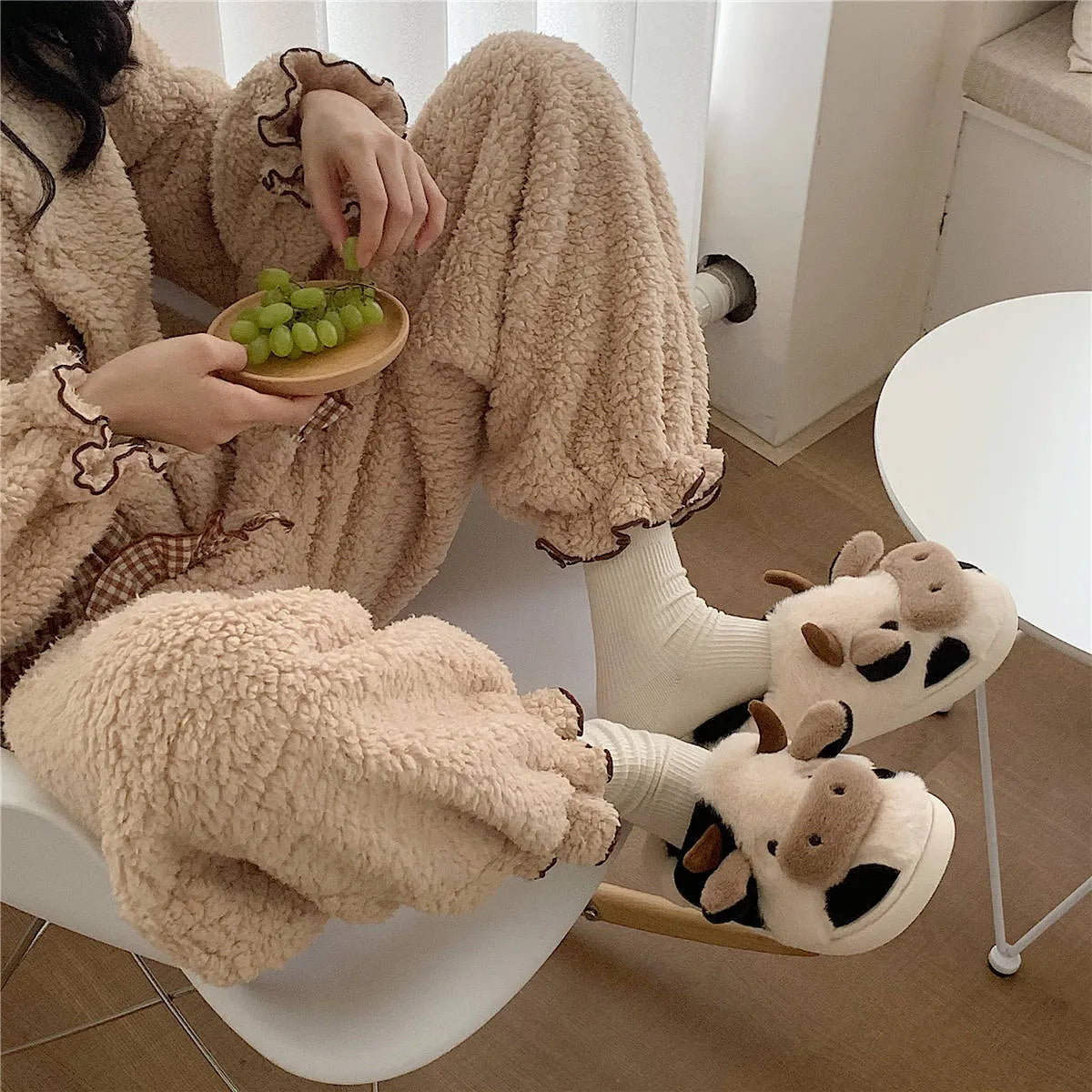 White cartoon cow slippers for women with fluffy faux fur and a textured non-slip sole.