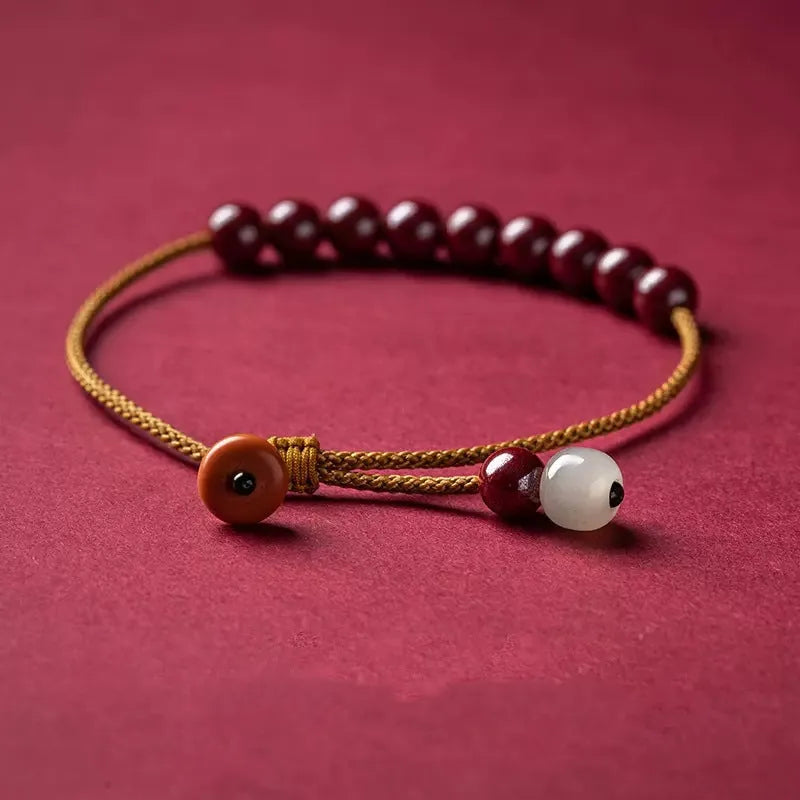 Hand-woven cinnabar and Hetian jade geometric bracelet on display