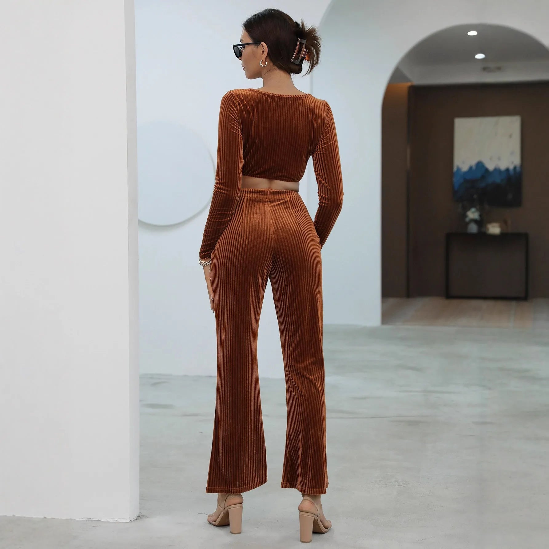 Caramel coloured long sleeve sweater and matching trousers loungewear set on a hanger