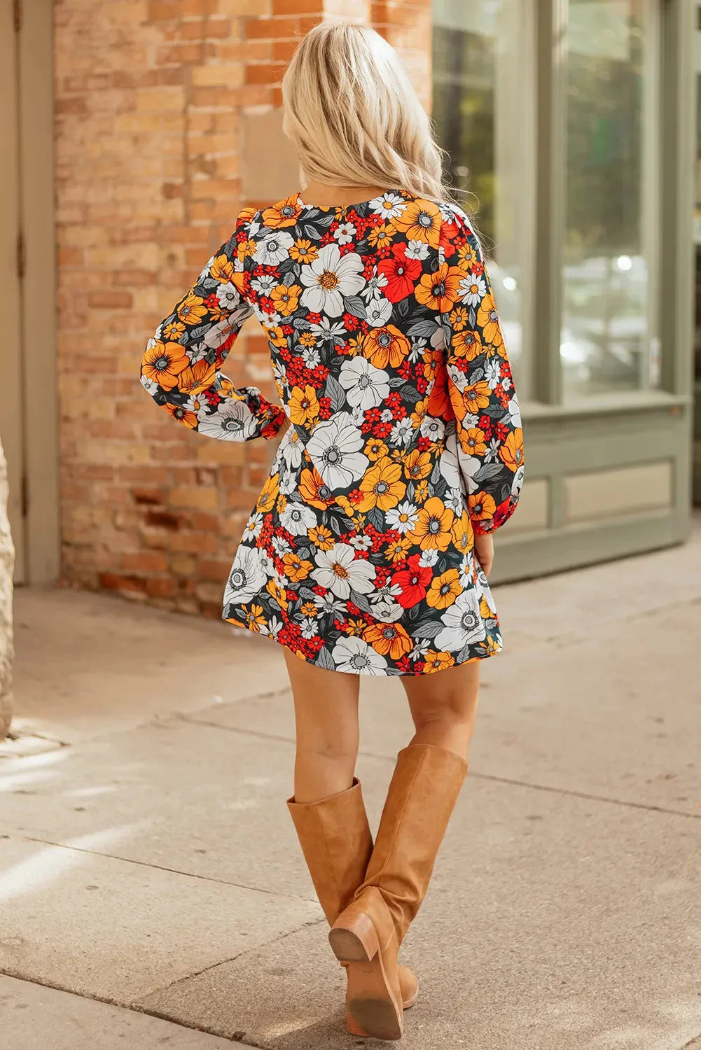 Orange floral and striped patterned mini dress with a lace-trimmed V-neck collar and long sleeves.