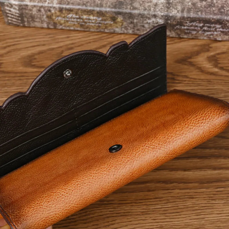 Brown genuine leather women's tri-fold wallet with embossed floral pattern showing interior compartments
