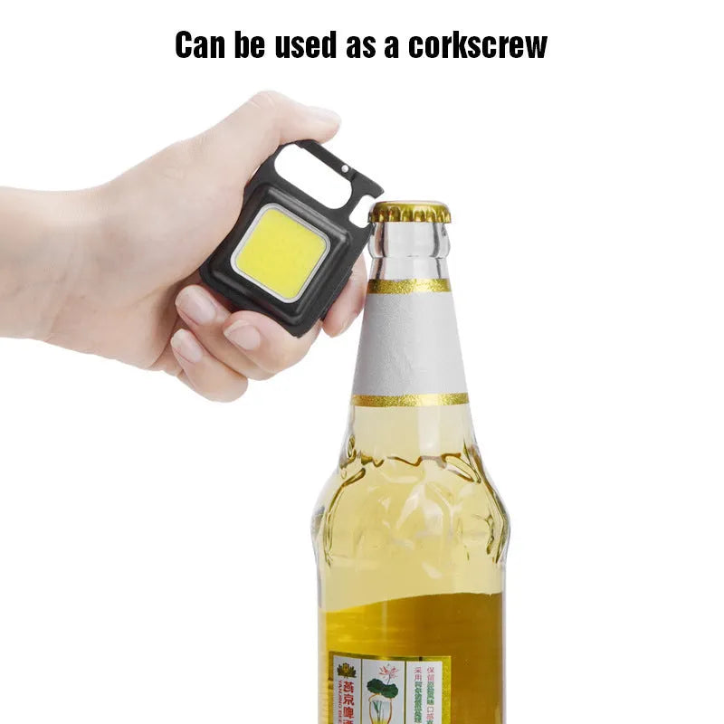 Black aluminium alloy keychain light with COB LED, magnetic base, and foldable handle on keyring