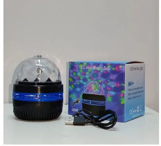 LED rotating magic ball galaxy projector lamp with remote control on a bedside table.