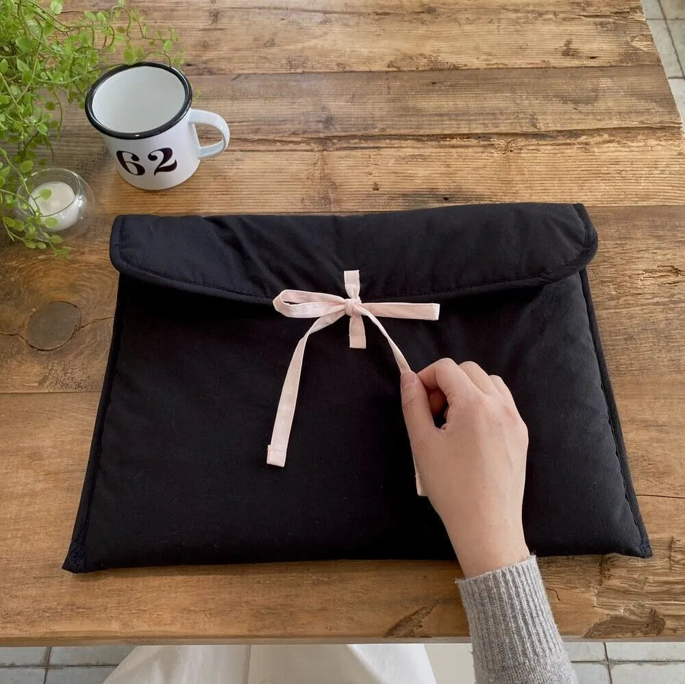 Women's black and white quilted laptop bag with decorative bow in two size options