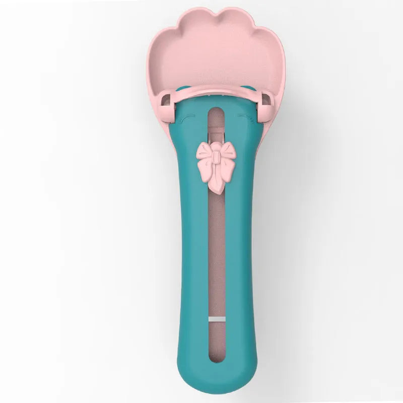 Plastic pet food squeezer dispenser in pink and green colours for feeding cats and puppies.