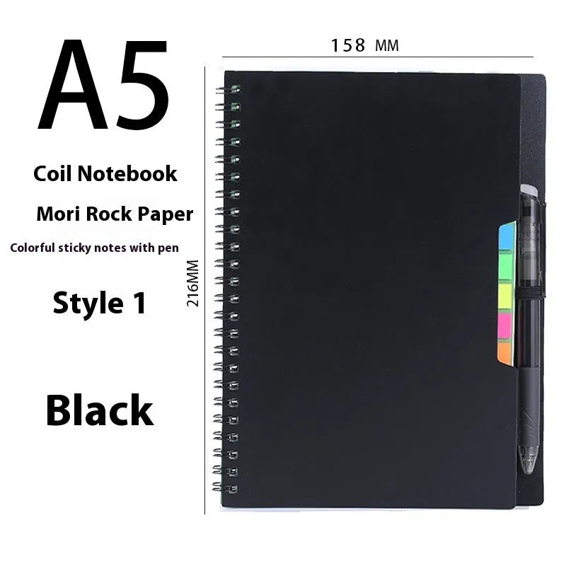 Erasable spiral notebook with stone paper, pen, and cloth on a wooden table