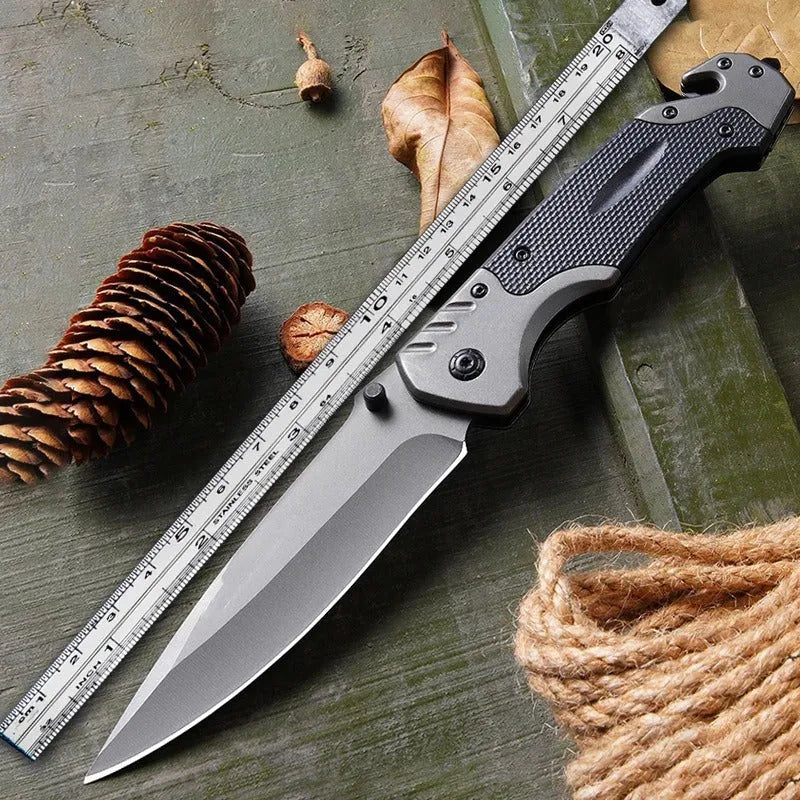Portable folding knife with alloy blade, 225mm full length, on outdoor surface