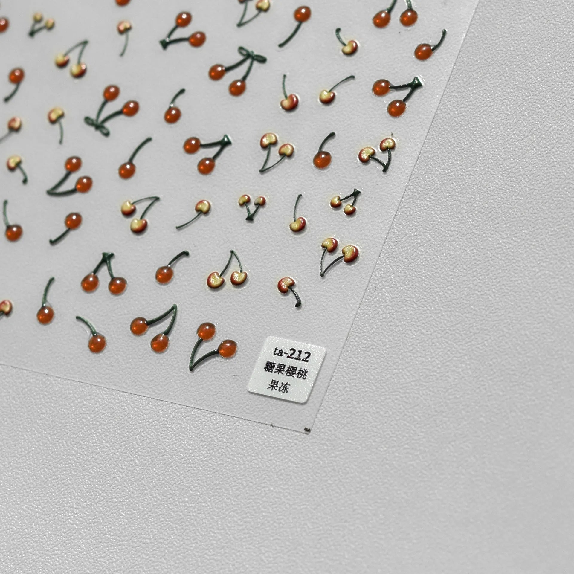 Jelly nail art sticker sheet with multiple cartoon cherry designs on a clear plastic backing
