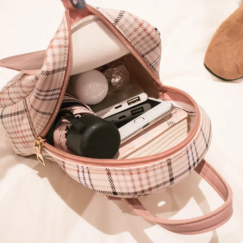 A black synthetic PU leather one shoulder diagonal phone bag with a strap, shown handheld.