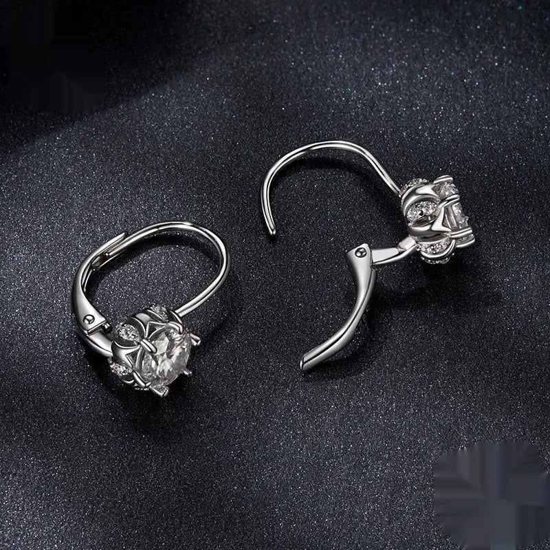 Close-up of a sterling silver floral bud ear clip with a moissanite stone and white gold plating.