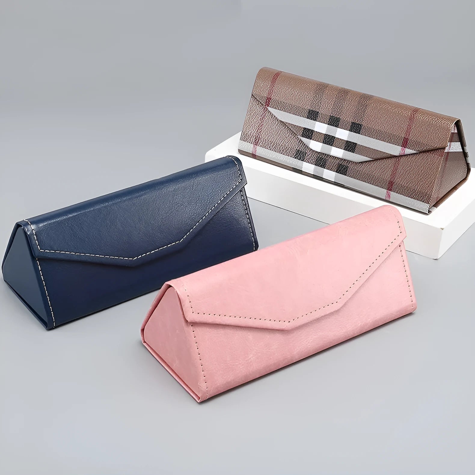 Folding glasses case in PU cowhide with triangle compression-resistant design, available in black, brown, pink, dark blue, calfskin black, and plaid