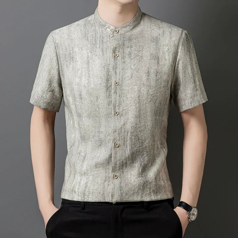 A man wearing a loose-fitting, short-sleeved casual shirt with a stand collar in a grey colour.