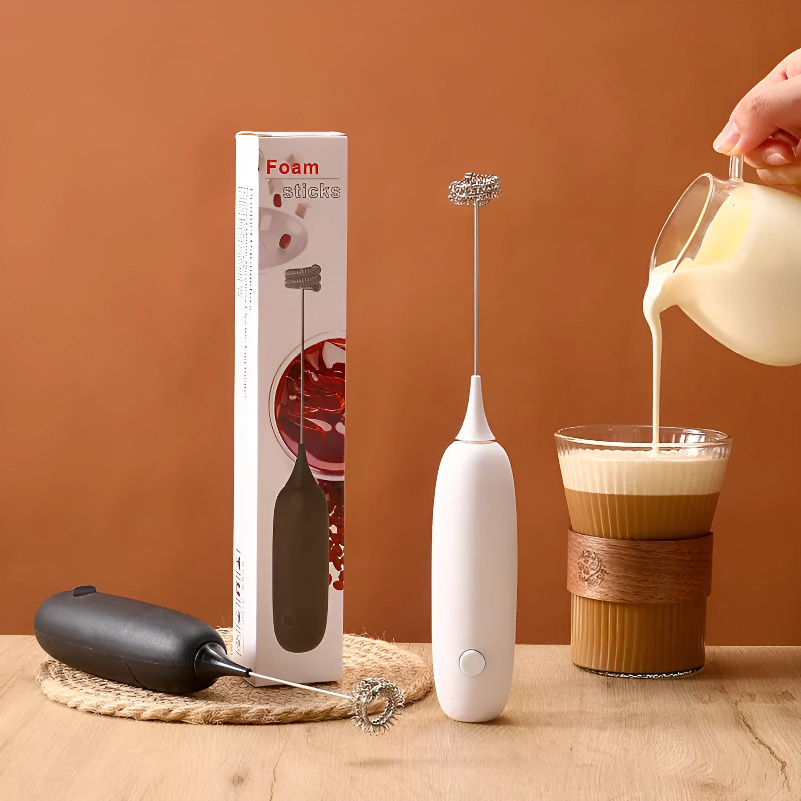 Black and white hand-held electric milk frother blender for coffee beverages