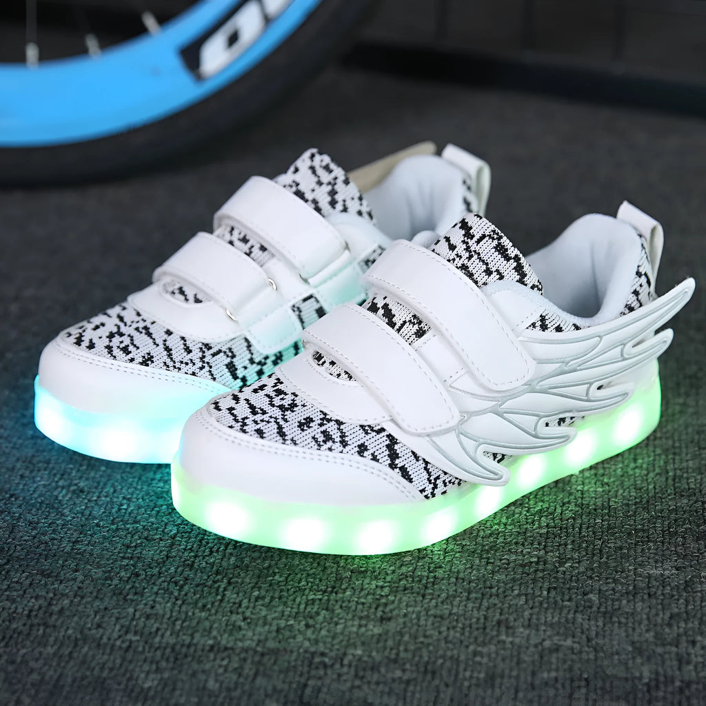 Children's plum red and white sneakers with colourful LED lights glowing on the side.