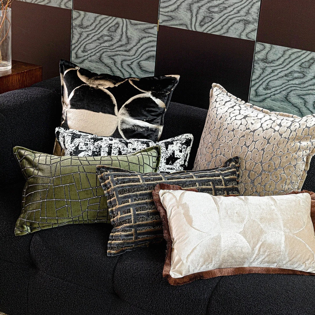 Black gold abstract patterned flannel decorative cushion on a sofa.