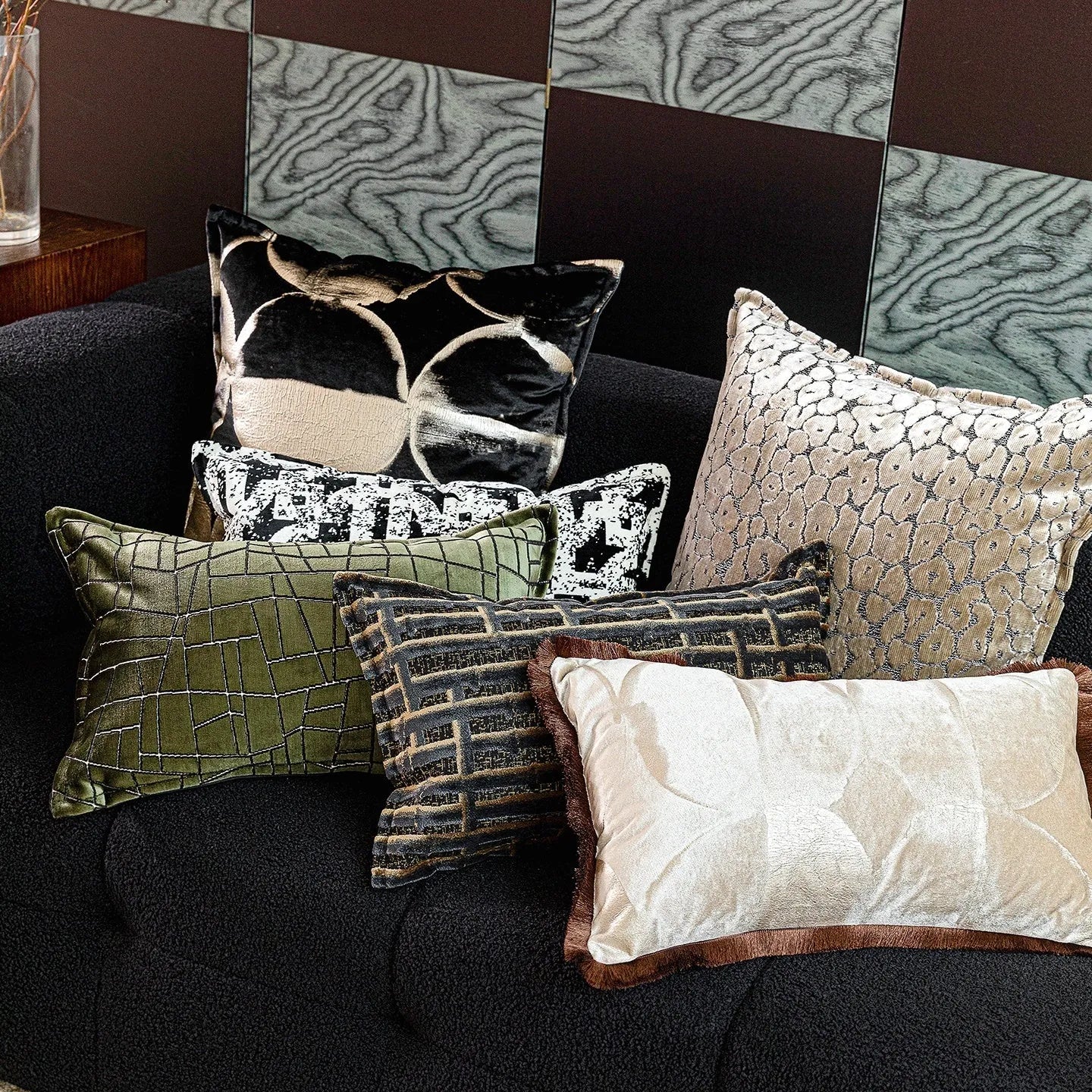 Black gold abstract patterned flannel decorative cushion on a sofa.