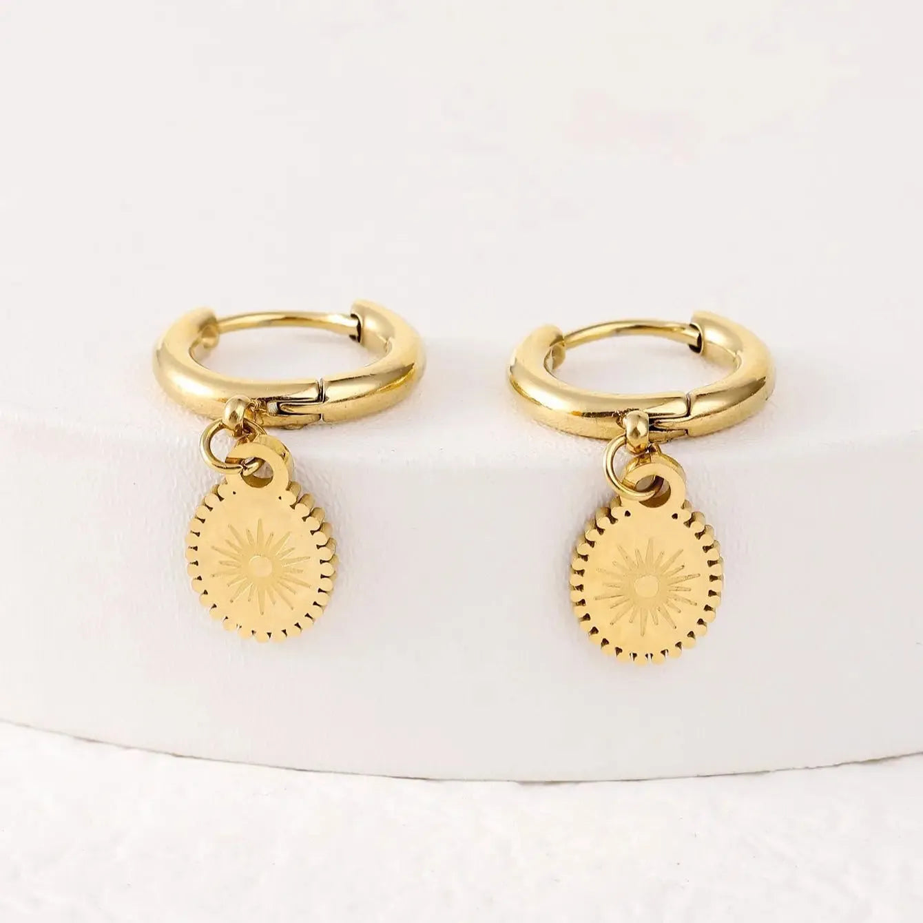A pair of stainless steel geometric ear button earrings with an ellipse detail, style XY-EH005.
