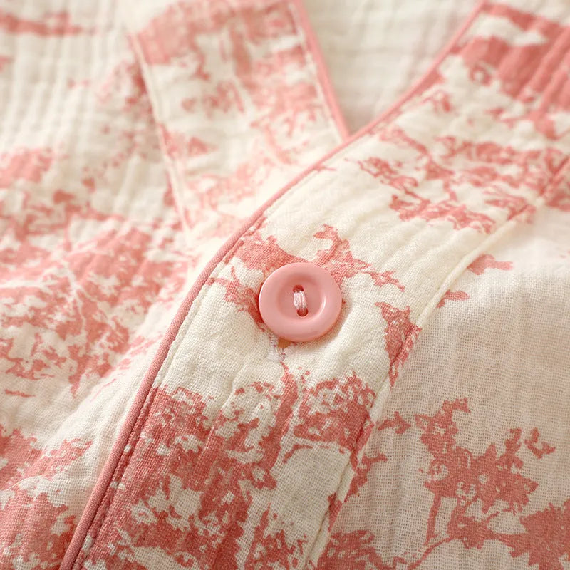 Women's pink pure cotton gauze suit with long sleeves and lace-up trousers on a hanger.