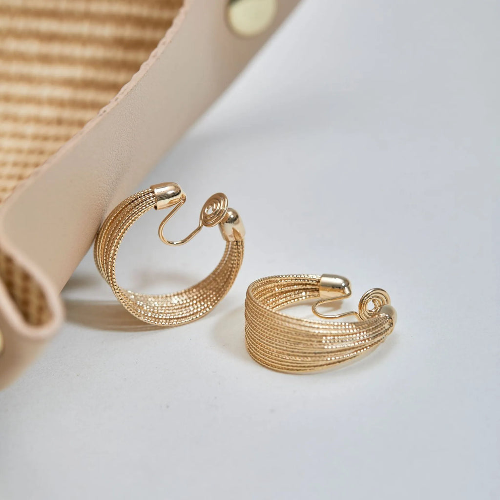 Geometric multi-layer copper earrings with an electroplated silver or gold finish, shown as studs and clips.